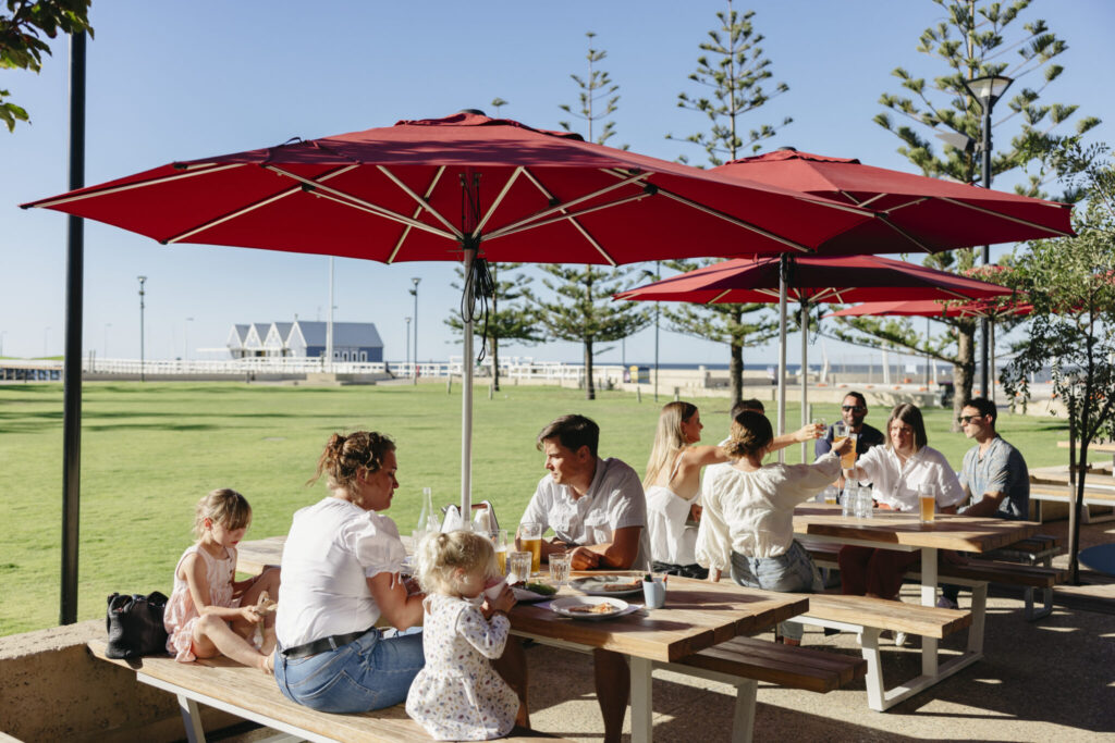 Photo of people seated outdoors with Busselton Jetty in the background