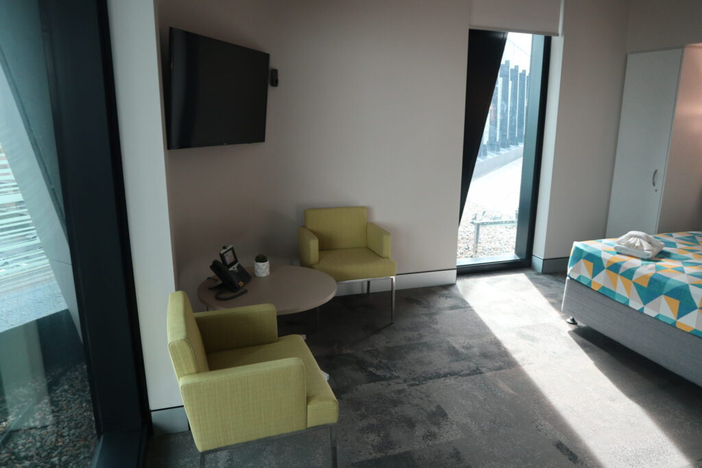 Photo of one of the ensuite rooms showing seating, a bed and the view from the room