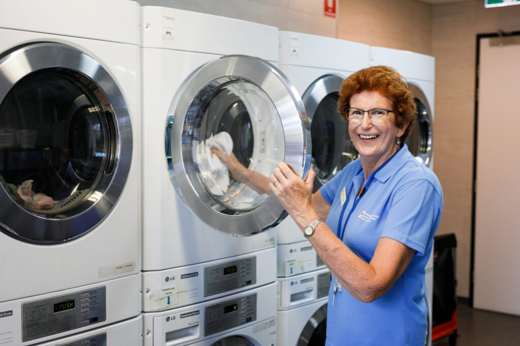 Photo of a volunteer in the laundry room of the Nedlands House