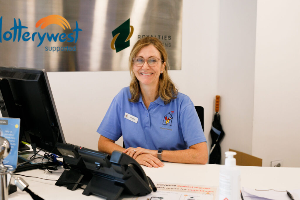 Photo of a volunteer at the front desk of the Nedlands House