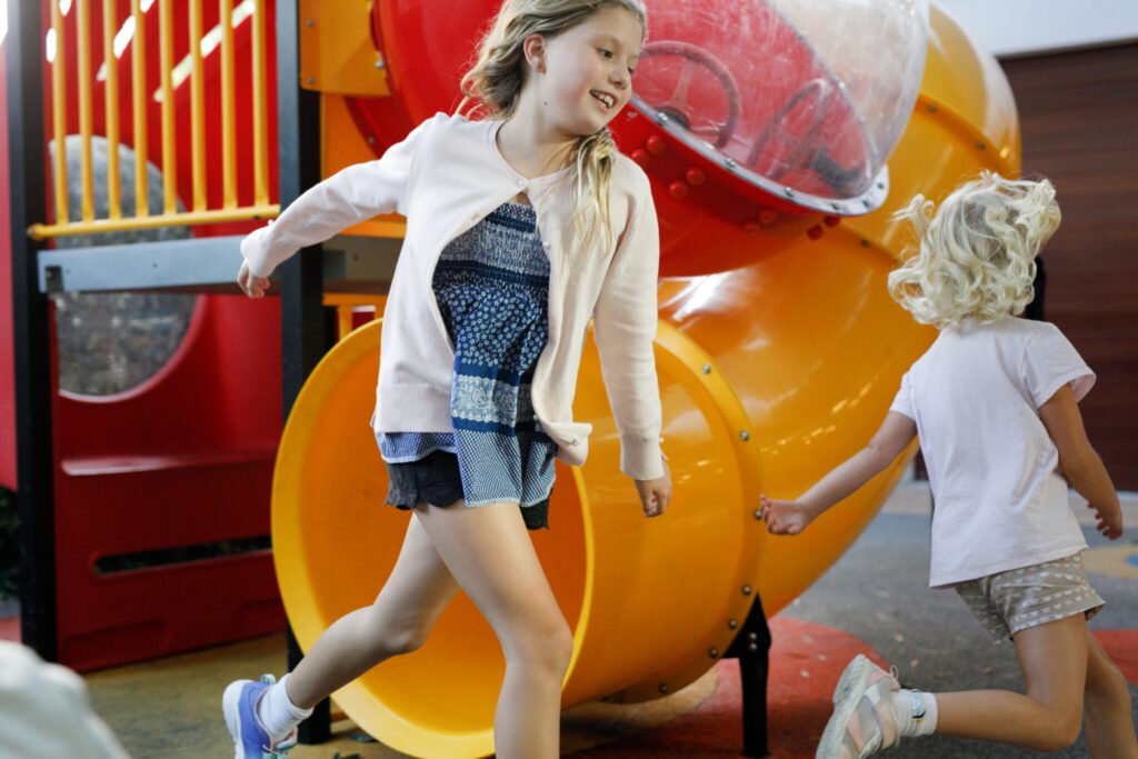 Photo of children running around the play fort and slides in the ground floor courtyard