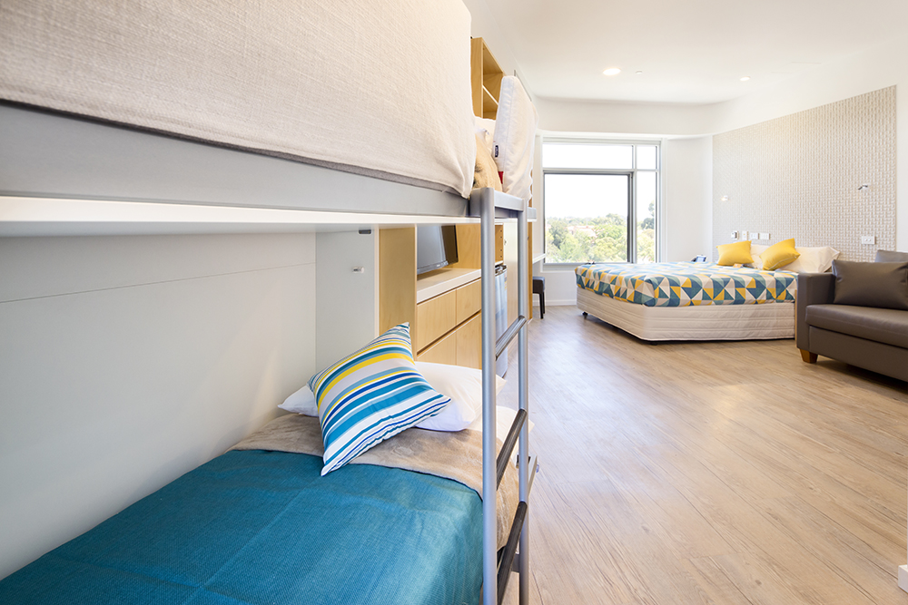 Photo of one of the ensuite rooms in the Nedlands house, showing 2 bunk beds set up along with a with a queen sized bed