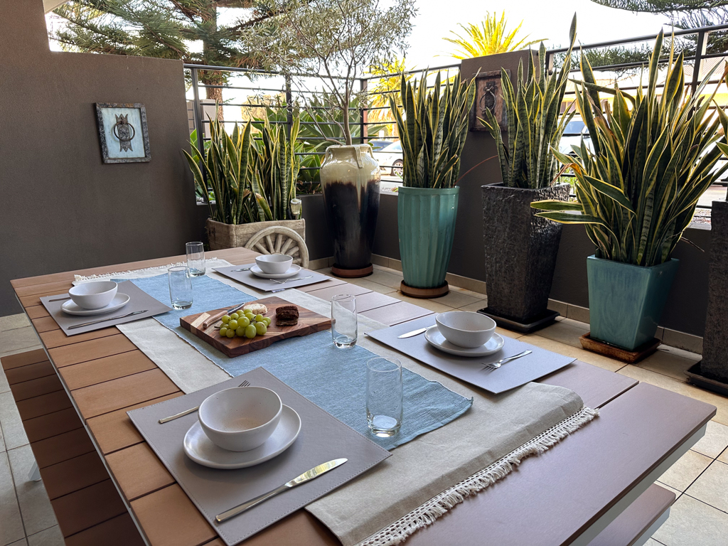 A photo of the main courtyard in the Ronald McDonald Family Retreat in Mandurah, with a dining table and bench seating