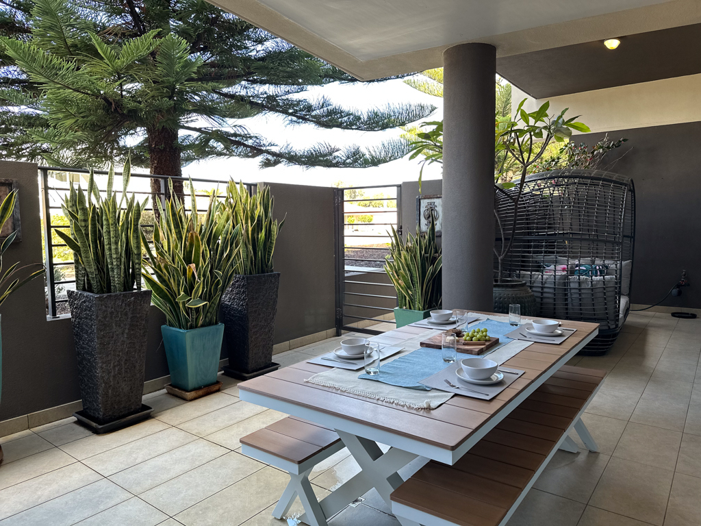 A photo of the main courtyard in the Ronald McDonald Family Retreat in Mandurah, with a dining table and bench seating