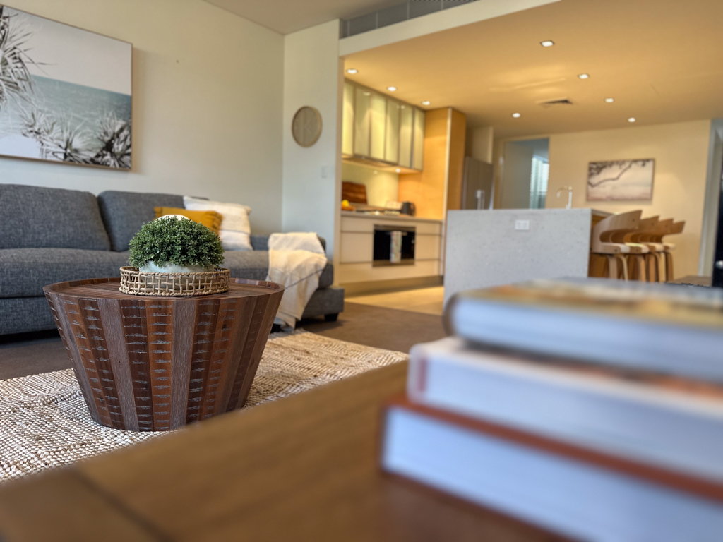 A photo of the loungeroom in the Ronald McDonald Family Retreat in Mandurah, showing a lounge and kitchen area with island bench seating.