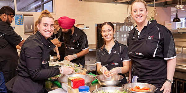 Team cooking dinner as part of the Home for Dinner experience