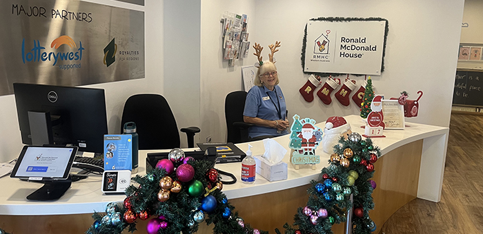 Volunteer staffing the visitors desk in RMH at QEII