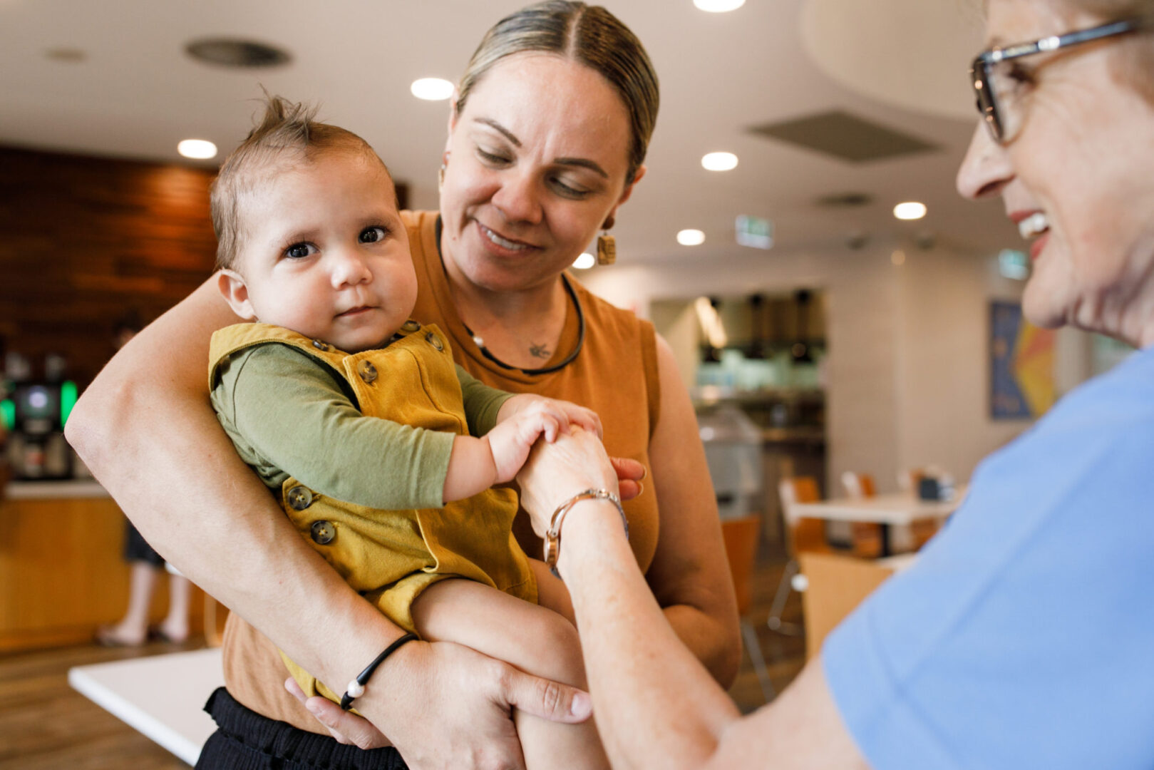 Photo of a mother holding her child while talking to a volunteer