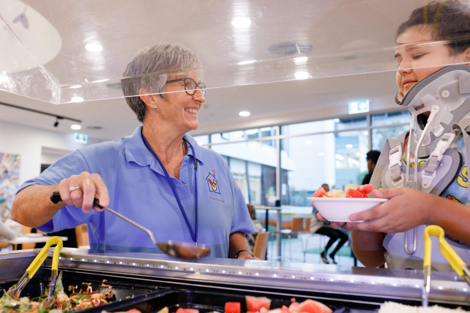 Photo of a volunteer serving a child dinner