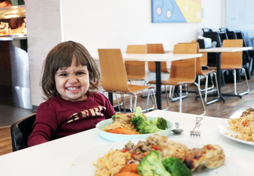 Photograph of a child in eating dinner in the dining room at Ronald McDonald House Nedlands