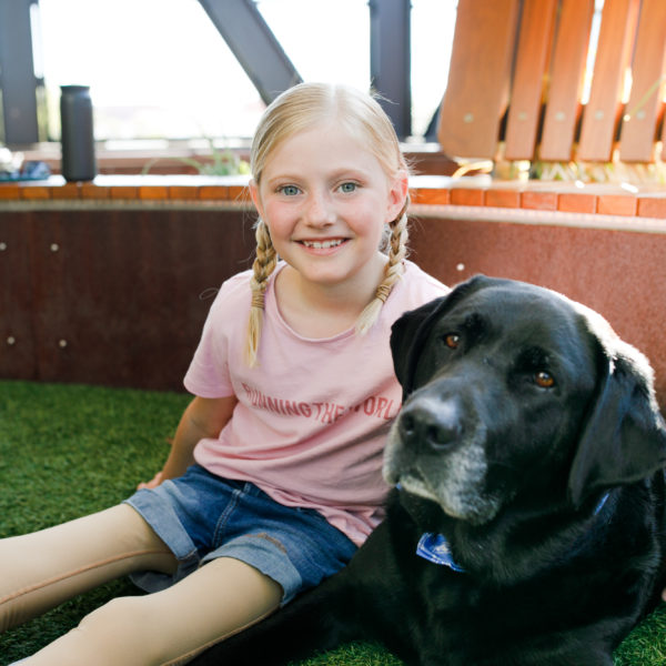 Photo of a child and Gus in the Minderoo Rooftop Courtyard at Ronald McDonald House Nedlands